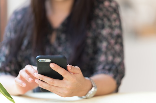 Close-up Uma mulher que trabalha com um telefone celular para verificar o e-mail