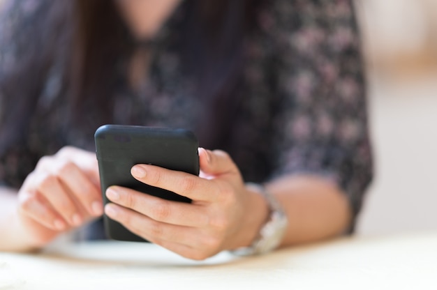 Close-up Uma mulher que trabalha com um telefone celular para verificar o e-mail