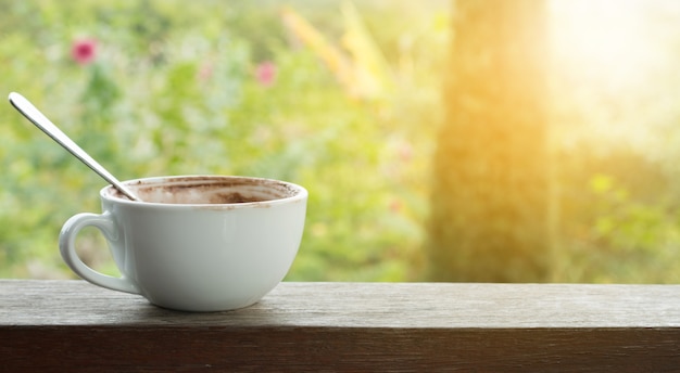 Close Up Uma xícara de café quente na mesa de madeira com verde refresque fundo natural