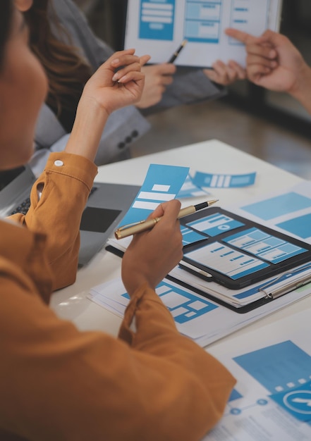 Close up ux desarrollador y ui diseñador utilizan realidad aumentada lluvia de ideas sobre la interfaz de la aplicación móvil diseño de wireframe en el escritorio en la oficina moderna agencia de desarrollo digital creativa