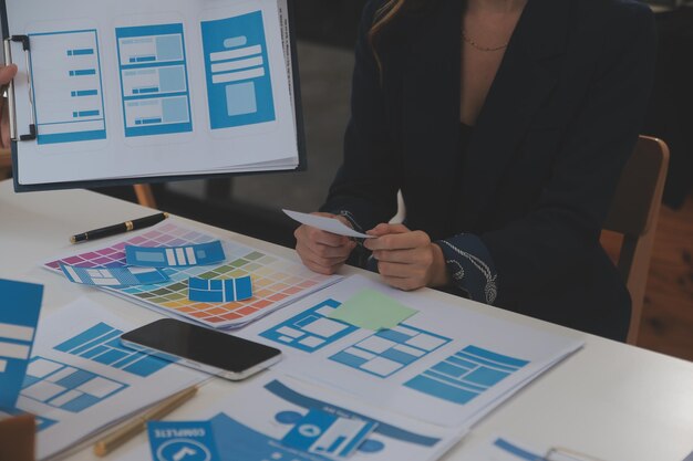 Close up ux desarrollador y ui diseñador utilizan realidad aumentada lluvia de ideas sobre la interfaz de la aplicación móvil diseño de wireframe en el escritorio en la oficina moderna agencia de desarrollo digital creativa