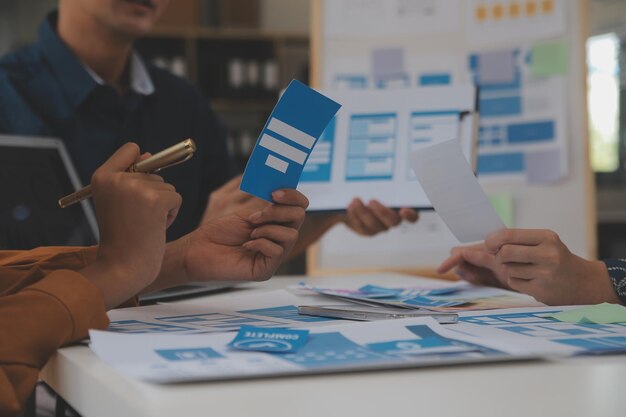 Close up ux desarrollador y ui diseñador utilizan realidad aumentada lluvia de ideas sobre la interfaz de la aplicación móvil diseño de wireframe en el escritorio en la oficina moderna agencia de desarrollo digital creativa