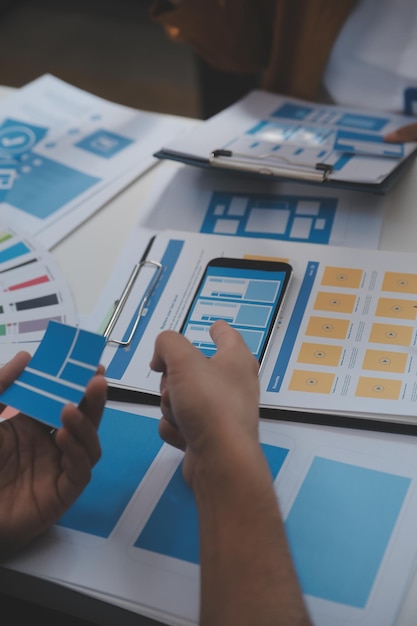 Close up ux desarrollador y ui diseñador utilizan realidad aumentada lluvia de ideas sobre la interfaz de la aplicación móvil diseño de wireframe en el escritorio en la oficina moderna agencia de desarrollo digital creativa