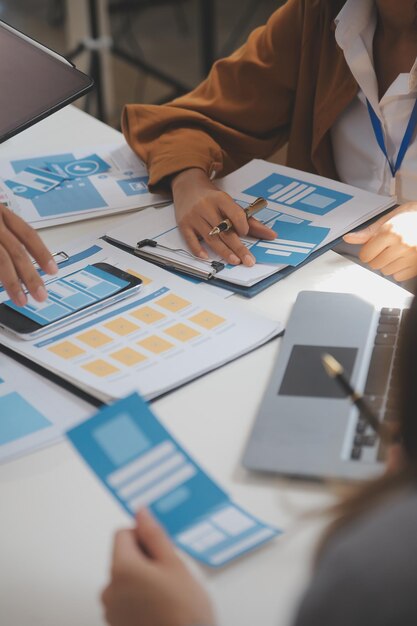 Close up ux desarrollador y ui diseñador utilizan realidad aumentada lluvia de ideas sobre la interfaz de la aplicación móvil diseño de wireframe en el escritorio en la oficina moderna agencia de desarrollo digital creativa