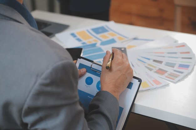 Close up ux desarrollador y ui diseñador utilizan realidad aumentada lluvia de ideas sobre la interfaz de la aplicación móvil diseño de wireframe en el escritorio en la oficina moderna agencia de desarrollo digital creativa
