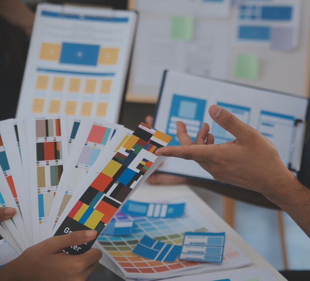 Close up ux desenvolvedor e ui designer usar realidade aumentada brainstorming sobre interface de aplicativo móvel wireframe design na mesa em escritório modernoAgência de desenvolvimento digital criativa