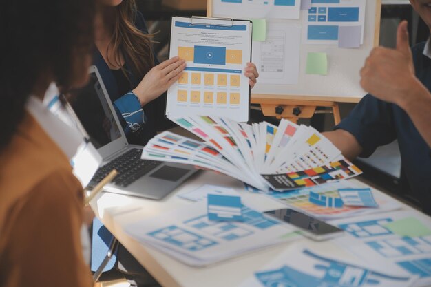 Close-up-UX-Entwickler und UI-Designer nutzen Augmented-Reality-Brainstorming über das Wireframe-Design der Mobil-App-Schnittstelle am Schreibtisch in einer modernen Büro-Kreativ-Digital-Entwicklungsagentur.