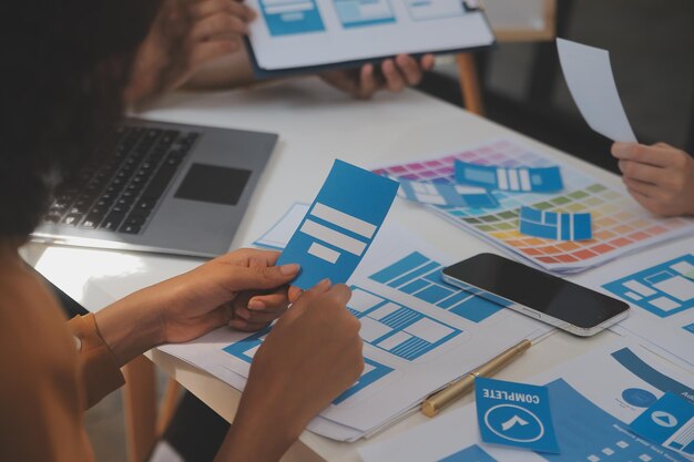 Close-up-UX-Entwickler und UI-Designer nutzen Augmented-Reality-Brainstorming über das Wireframe-Design der Mobil-App-Schnittstelle am Schreibtisch in einer modernen Büro-Kreativ-Digital-Entwicklungsagentur.