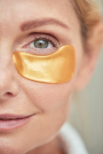 Foto close-up vista da metade do rosto de mulher caucasiana de meia idade com tapa-olho, olhando para a câmera. conceito de beleza, cuidados com a pele e cosmetologia