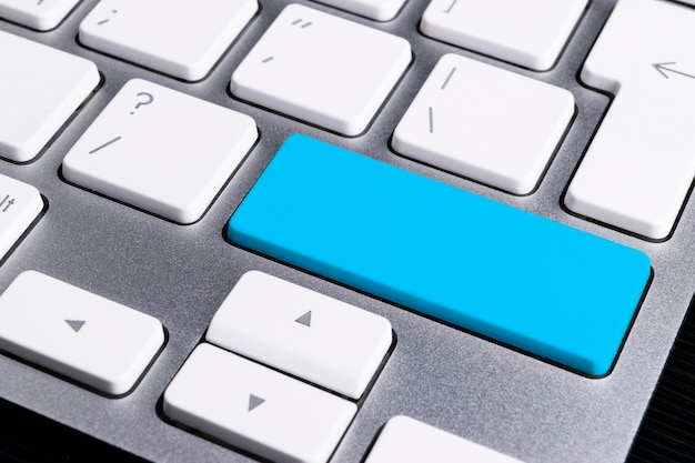 Close-up vista de um teclado de notebook com uma tecla azul, fundo de tecnologia, espaço vazio para texto