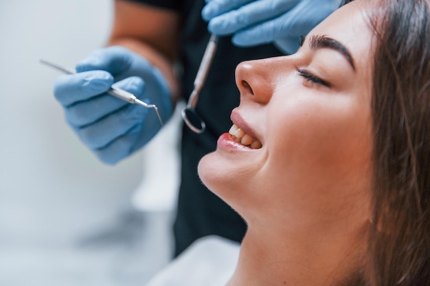 Close-up vista de uma jovem adulta que tem uma visita na clínica do dentista. concepção de estomatologia.