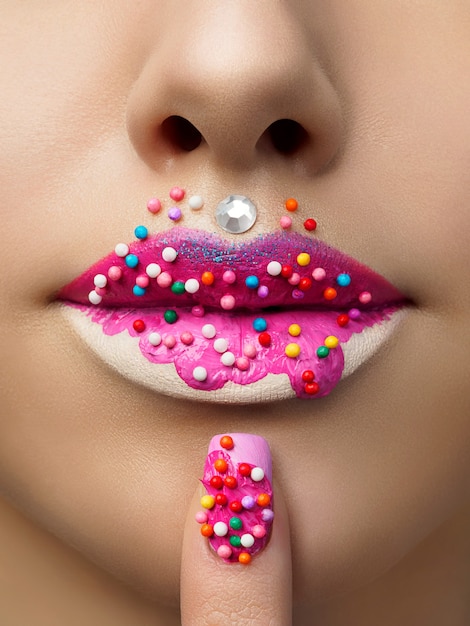 Close-up vista dos lábios femininos com maquiagem doce de donut. Conceito de maquiagem, sobremesa ou junk food da moda. Foto macro do estúdio