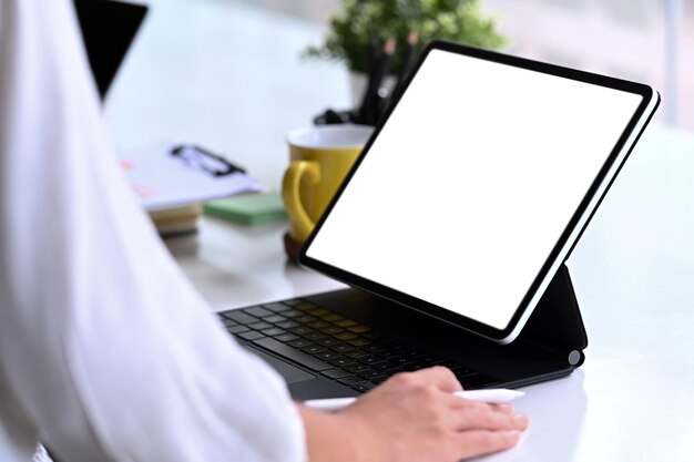 Close-up vista empresária trabalhando com computador tablet na mesa de escritório.