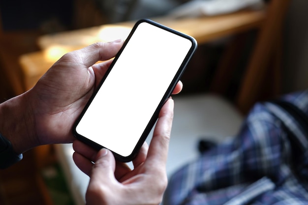 Foto close-up vista homem mãos segurando um telefone inteligente com tela em branco para anunciar texto