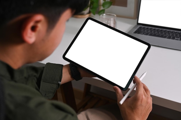 Close-up vista jovem empresário usando tablet digital no local de trabalho confortável