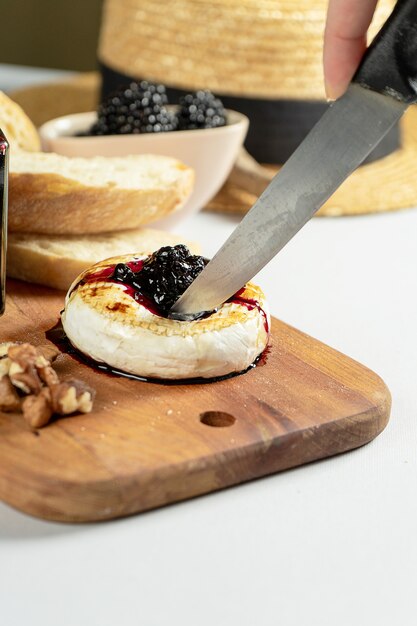 Foto close-up vista no camembert grelhado com geléia de amora, nozes e chiabatta em fundo cinza. copie o espaço. queijo. comida saborosa para o almoço. foco suave. alimento para o vinho