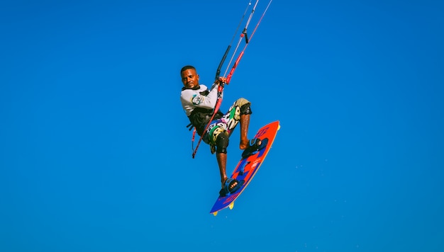 Close-up voando kitesurfer no céu azul. Egito.