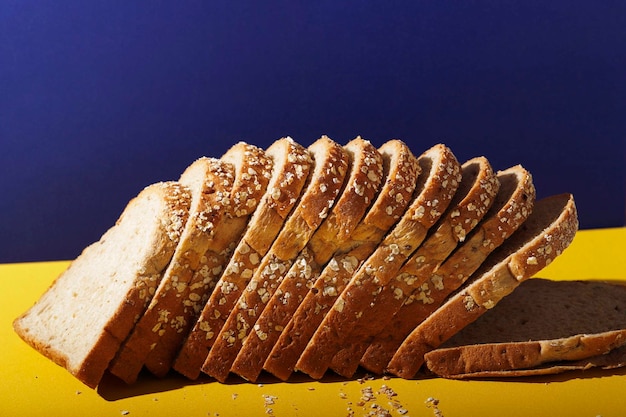 Close Up Vollkornbrot mit Haferflocken und Samen auf Blau und Gelb