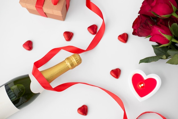 Close-up von Champagner, Geschenkkonserven und roten Rosen