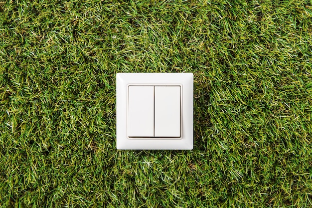 Close-up von Lichtschalter auf grünem Gras-Hintergrund