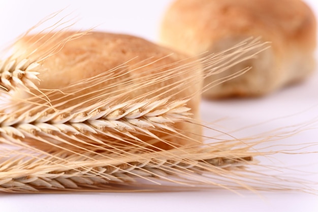 Close up Weizenähren und Brötchen im Hintergrund