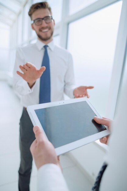 Close upGeschäftsmann mit digitalem Tablet auf Bürohintergrund