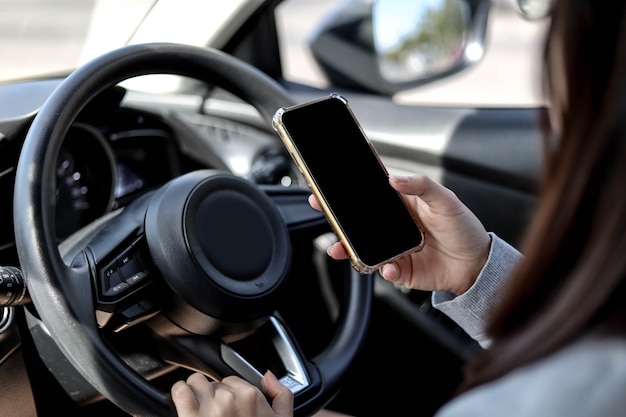 Close-ups de mulheres segurando o volante e usando o telefone celular enquanto dirige, usando o telefone enquanto dirige é perigoso e ilegal, conceito de direção segura, não use seu telefone enquanto dirige.