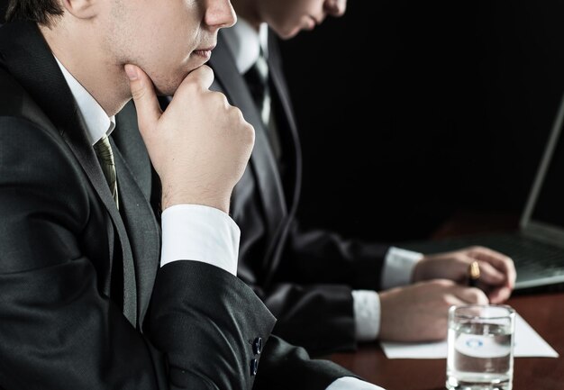 Close upthoughtful Geschäftsmann sitzt an seinem Schreibtisch