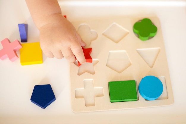 Closeup Baby spielt Lernen und Entwicklung von Kleinkindern Ökologisches Lernspielzeug aus Holz Montessori-System