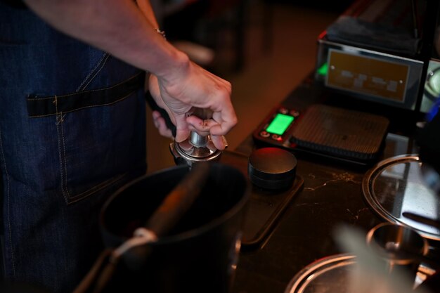 Closeup Barista masculino preparando café pressionando café moído para fabricação de cerveja