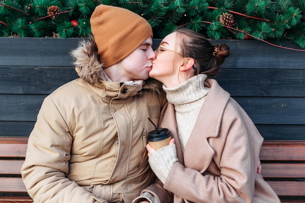 Closeup beijo doce retrato de jovem casal apaixonado se divertindo juntos ao ar livre na rua.