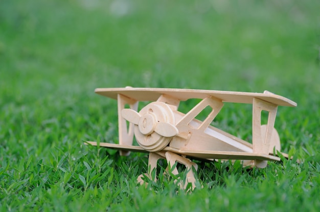 Closeup brinquedo de avião de madeira no fundo do chão de grama