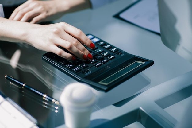 .closeup.Business-Frau mit einem Taschenrechner am Arbeitsplatz.