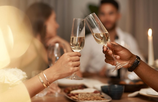 Closeup champanhe e copos para festa de comemoração ou amigos desfrutam do jantar de Ano Novo ou bebem juntos Brinde de mãos e álcool para beber evento e comida para reunião social saúde ou relaxar