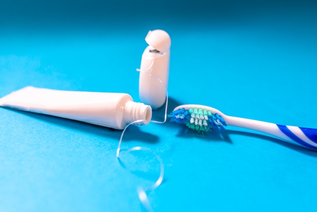 Closeup da escova de dentes com creme dental e fio dental.