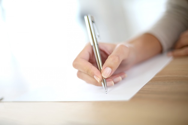 Foto closeup da mão da mulher, escrevendo em papel