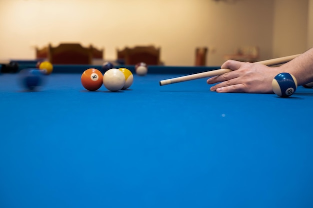 Closeup da mão de um homem em uma mesa de bilhar jogando sinuca se preparando para atirar bolas de bilhar esporte