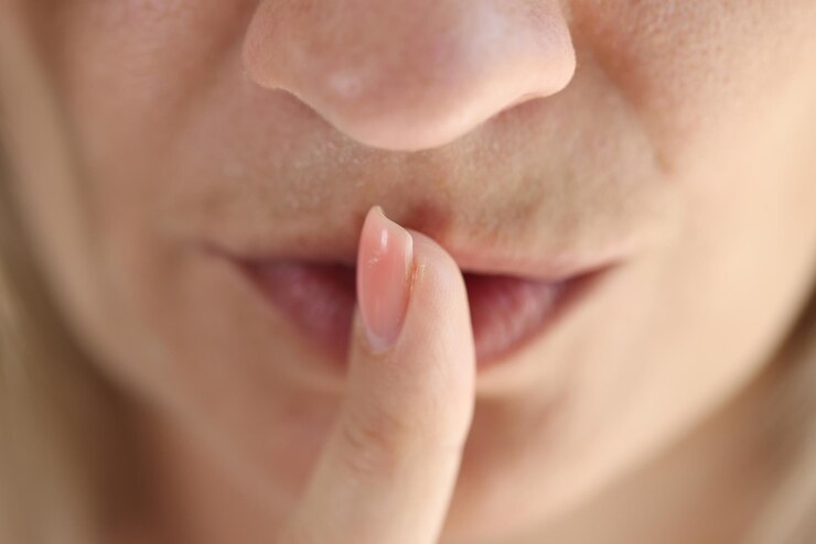 Foto closeup da mulher mostrando o gesto shh ou para manter o símbolo silencioso mulher segurando o dedo perto dos lábios