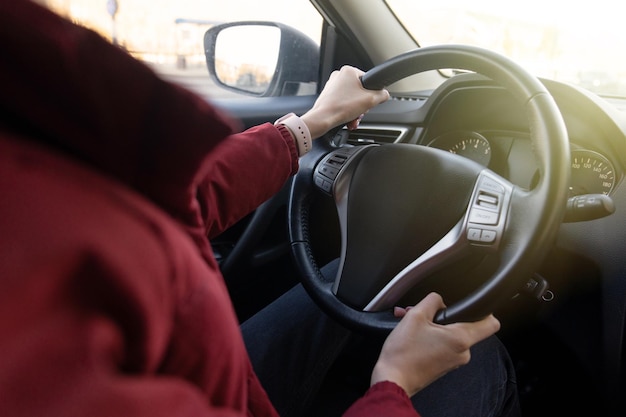 Closeup das mãos de uma mulher ao volante de um carro