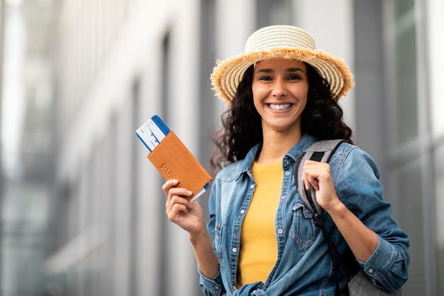 Closeup de alegre mulher bonita segurando passaporte e bilhetes