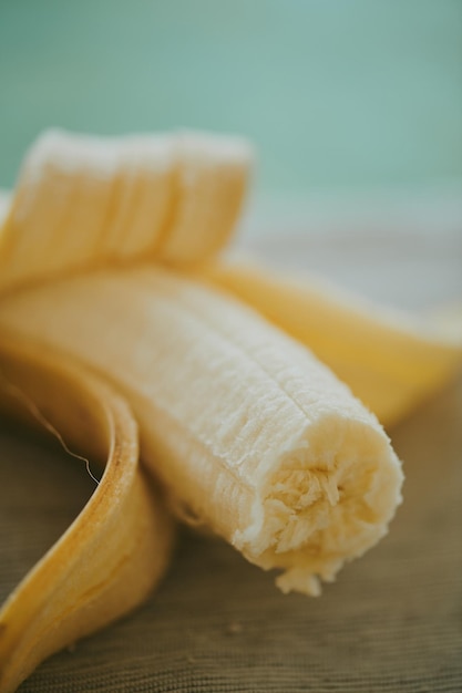 Closeup de banana fatiada descascada no fundo da mesa de madeira