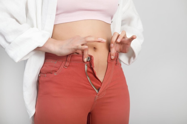 Foto closeup de barriga jovem não pode usar calças de verão dieta conceito de obesidade com sobrepeso