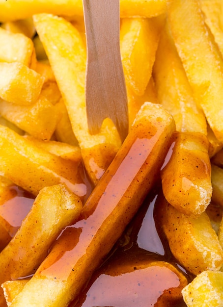 Closeup de batatas fritas com ketchup de curry