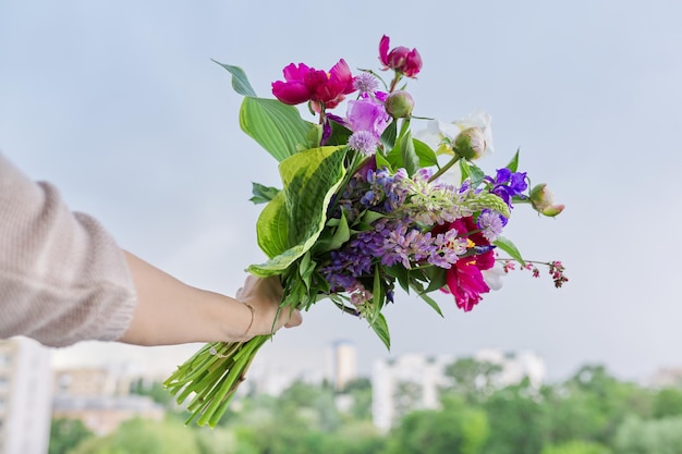 Closeup de brilhante buquê de flores na mão feminina