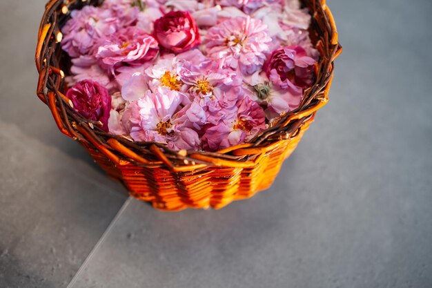 Closeup de buquê de rosas de chá na cesta de madeira no fundo do laminado cinza