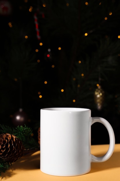 Closeup de caneca de cerâmica branca em um fundo festivo de Ano Novo com luzes de desfocagem