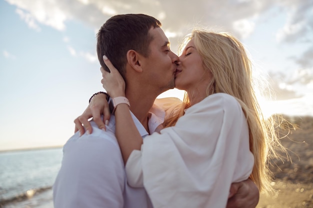 Closeup de casal feliz beijando em pé à beira-mar