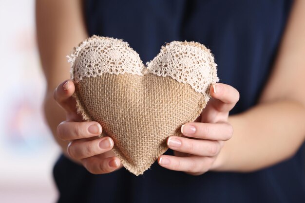 Closeup de coração de artesanato em mãos femininas