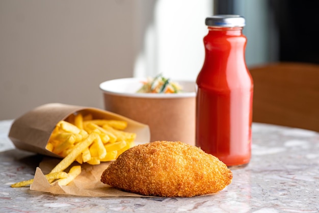 Closeup de costeletas de frango kiev Bebida de salada e batatas fritas Fast food na rua