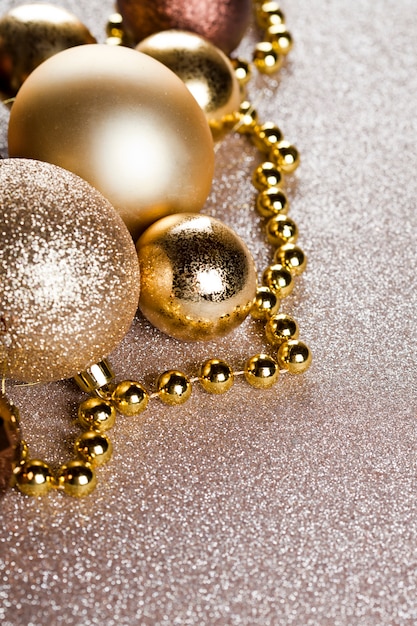 Closeup de decorações de ouro e marrom de Natal em fundo de brilho.